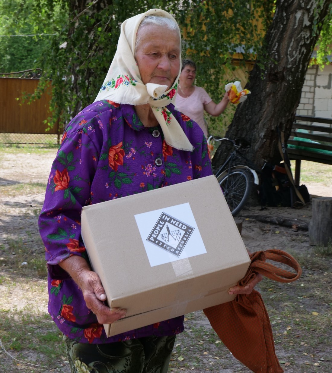 elderly woman holding a box of supplies