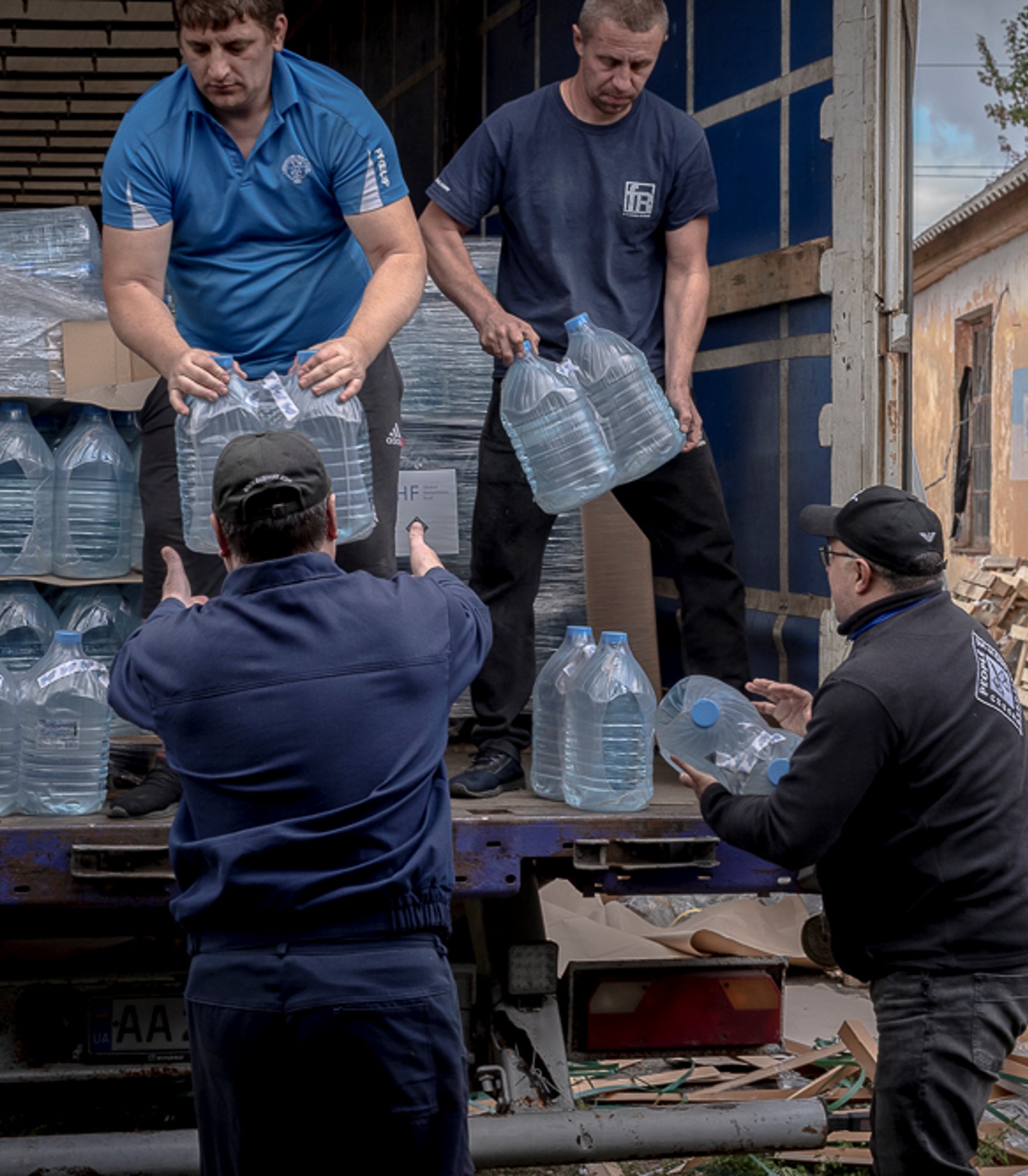 men off loading water bottles from a truck