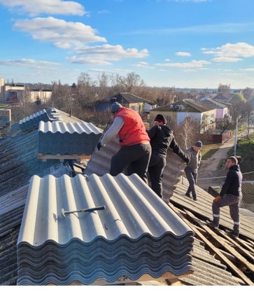 men on a roof with building materials